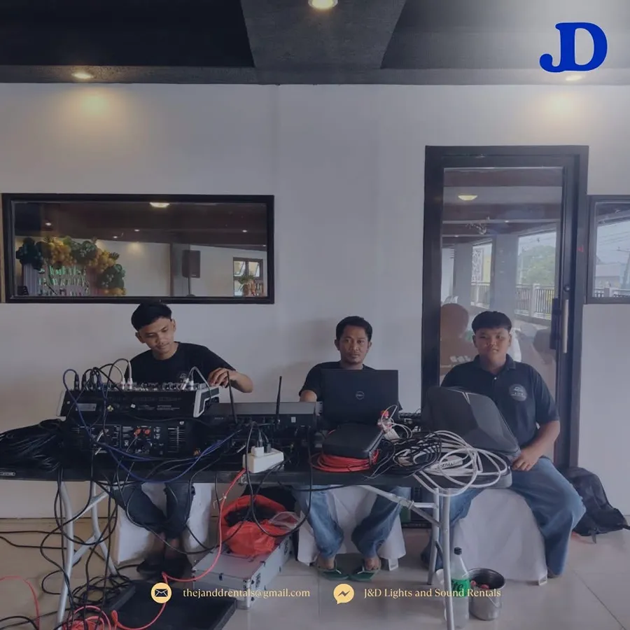 J&D crew seated at the mixing console and laptops, running sound during an event