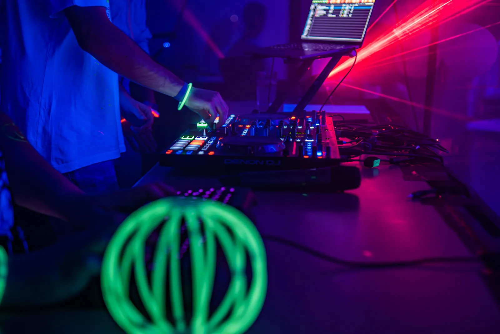 Debut dance floor lit by moving head fixtures with fog catching the beams